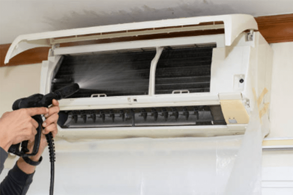 technician man cleaning the air conditioner